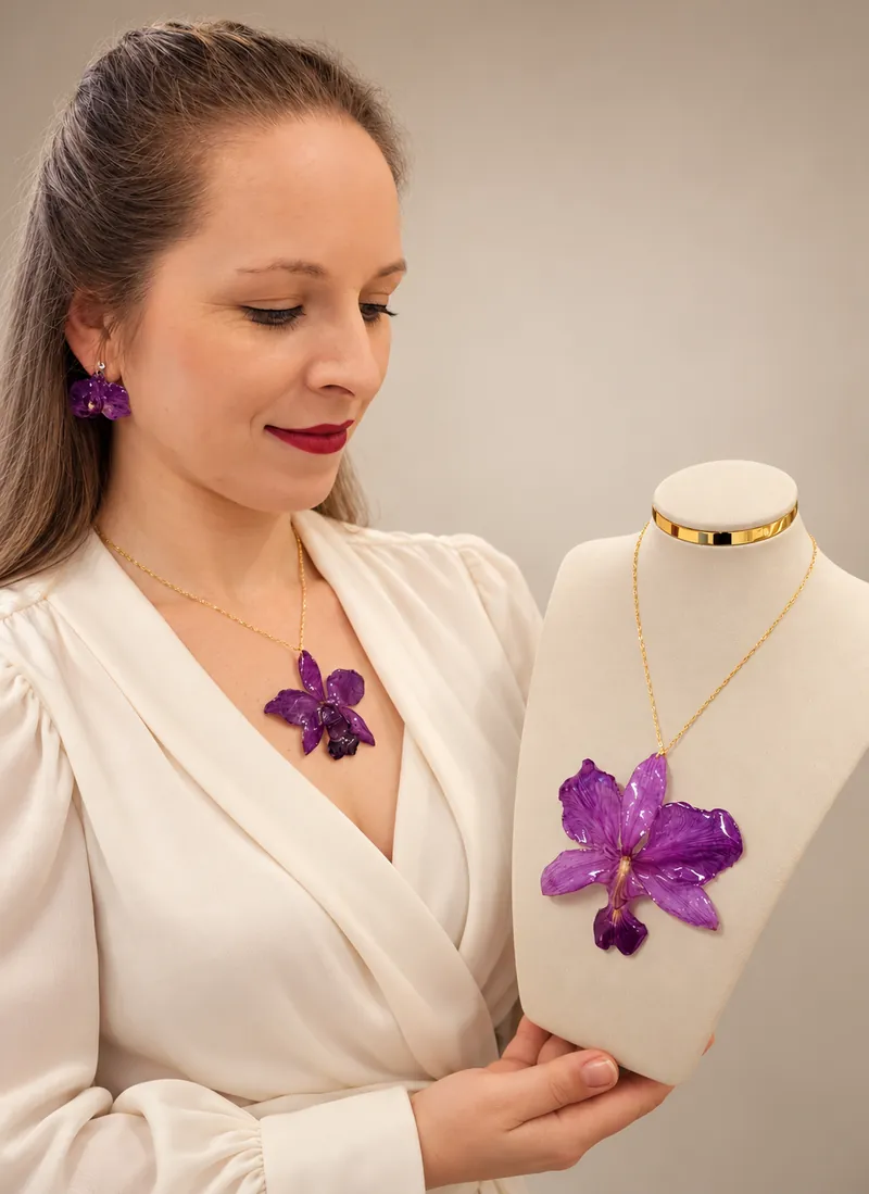 Ana com colar e brinco de orquídea natural ao lado de um colar de orquídea roxa